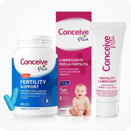 Conceive Plus Men's Combo - Fertility Support + Lubricant (IT) featuring a white bottle of men's fertility support capsules with blue label and two blue capsules, placed beside a pink box and white tube of fertility lubricant featuring Italian text and a baby image, all displayed on a white background.