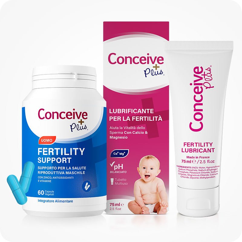 Conceive Plus Men's Combo - Fertility Support + Lubricant (IT) featuring a white bottle of men's fertility support capsules with blue label and two blue capsules, placed beside a pink box and white tube of fertility lubricant featuring Italian text and a baby image, all displayed on a white background.